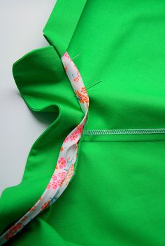 the back of a green dress with flowers on it