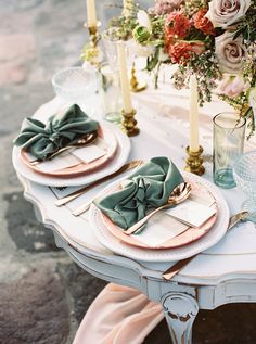 a table set with place settings and flowers