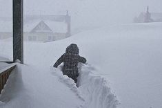 a person is walking through the snow in front of a sign that says mam, horvyo r