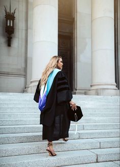 a woman in graduation gown standing on steps