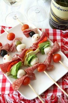 a white plate topped with meat and veggies next to a bottle of wine