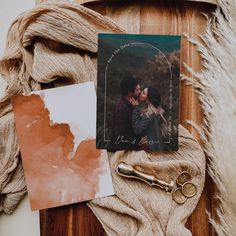 a couple kissing in front of an old photo and some other items on a table