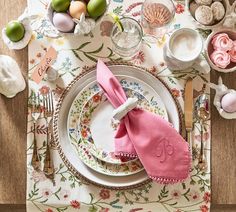 an easter table setting with pink napkins and eggs