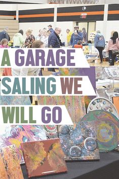 there is a table with paintings on it and the words a garage selling we will go