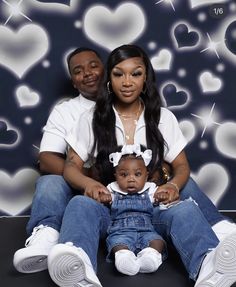 a man and woman sitting next to a baby