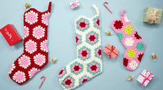 three crocheted christmas stockings and decorations on a blue background