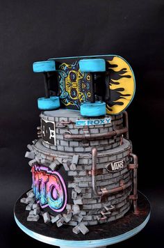 there is a cake that looks like a brick wall with skateboards on top and flames coming out of it