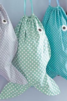 three bags are hanging on the wall with fish eyes and polka dotty fabric in different colors