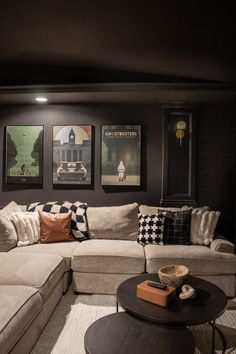 a living room with couches and pictures on the wall above them, along with a coffee table