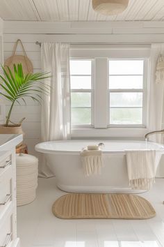 a bathroom with white walls and floors has a large bathtub in the middle of the room