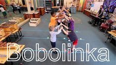 several children are doing handstand exercises in a room full of tables and desks