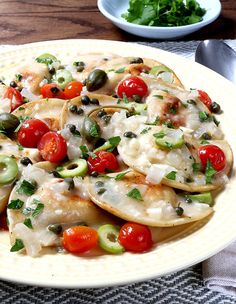 a white plate topped with nachos covered in cheese and tomatoes