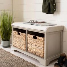 a bench with baskets underneath it and a coat rack on the wall next to it