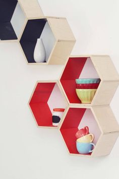 three hexagonal shelves with bowls and cups on them