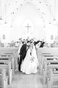 black and white photo of bride and groom kissing in front of pews at church