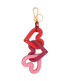 a red and pink keychain hanging from a gold hook on a white background