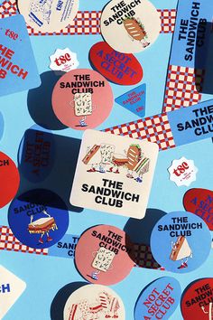 the sandwich club stickers are scattered on a blue background with red, white and blue checkered squares