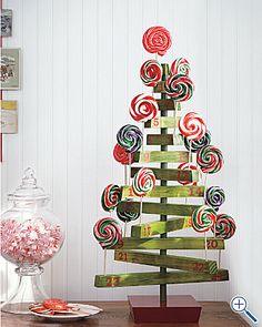 a wooden christmas tree with lollipops on it