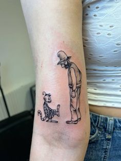 a woman with a tattoo on her arm has a cat and dog in front of her