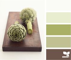 an artichoke on a cutting board with color swatches