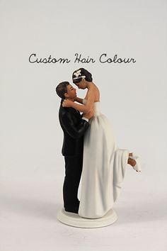 a wedding cake topper with a bride and groom holding each other in their arms