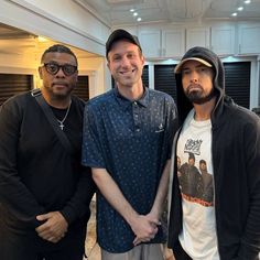 three men standing next to each other in a room