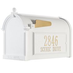 a white mailbox with gold lettering on it