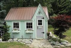 a small green house sitting on top of a lush green field next to some trees