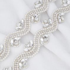 This gorgeous bridal trim is beaded with pearls and glass rhinestones and has an adhesive iron on backing. It will add sparkle to any bridal belt/sash, wedding gown, or headband! -Trim width: 1 inch -Sold by the yard, 1/2 yard, 1/4 yard, or 1/8 yard -Iron on backing -Clear rhinestones, imitation pearls, white stitching and iron on backing ::ABOUT THE SHOP:: Thanks for stopping by! I have been designing and making since 2010 and have several collections. I source most of my materials and crystals Embellished Silver Bridal Belt, Silver Embellished Bridal Belt, White Crystal Bridal Accessories With Rhinestones, White Crystal Bridal Belt With Rhinestones, White Rhinestone Bridal Belt, Beaded Crystal Bridal Belt For Wedding, Crystal Beaded Bridal Belt For Wedding, Crystal Bridal Accessories With Rhinestones For Bride, White Crystal Bridal Belt For Party