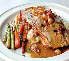 a white plate topped with meat and vegetables