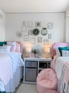 two beds in a room with pictures on the wall above them and a pink chair