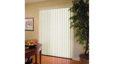 a living room with wooden floors and white vertical blinds