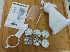 the contents of a kitchen aid device are laid out on a cutting board with scissors and other items