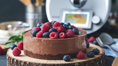 a chocolate cake with raspberries and blueberries on top