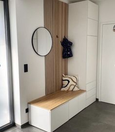 a room with a bench, mirror and coat rack on the wall next to it