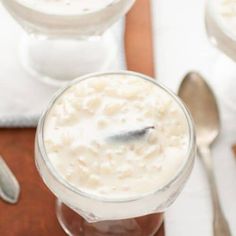 two glasses filled with oatmeal sitting on top of a wooden table