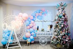 a room filled with balloons and a ferris wheel next to a christmas tree