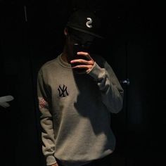 a man taking a selfie in front of a mirror wearing a new york yankees sweatshirt