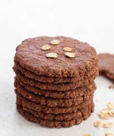 a stack of cookies sitting on top of a white table next to some oats