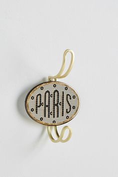 the word paris is written in black and white letters on a gold colored metal hook