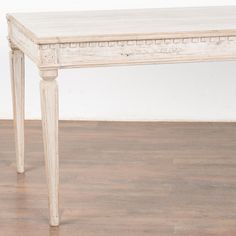 an old white table is sitting on the floor