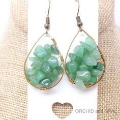 the earrings are made out of wire and glass beads, with green stones in them