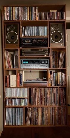 a bookshelf filled with lots of different types of audio equipment and music cassettes