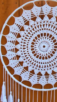 a white crocheted doily with tassels hanging from it