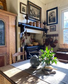 an old fashioned kitchen with potted plants on the table