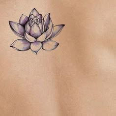 the back of a woman's stomach with a tattoo of a lotus flower on it