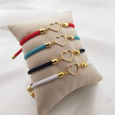 four bracelets with hearts on them sitting on a pillow