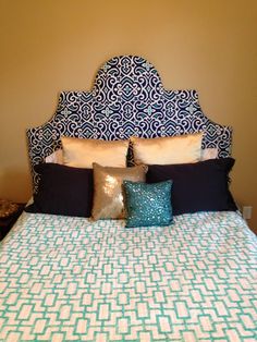 a large bed with blue and white pillows on it's headboard in a bedroom