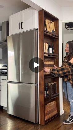 a woman standing in front of a refrigerator