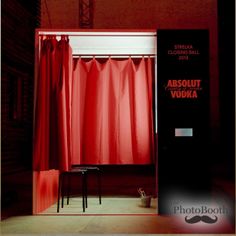 a red curtain is open in front of a black chair